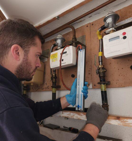 Heating engineer working on hot water system controls