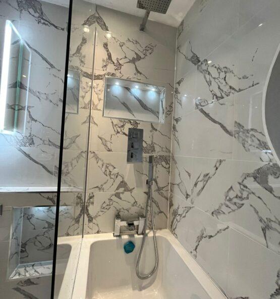Marble tiled bathroom with bathtub and plumbing fittings